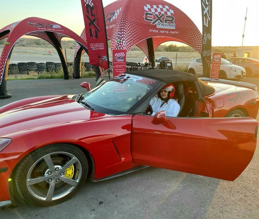 לקוחת EXR עם קסדה אדומה בקורבט C6 תחת הגזיבו בשעת שקיעה