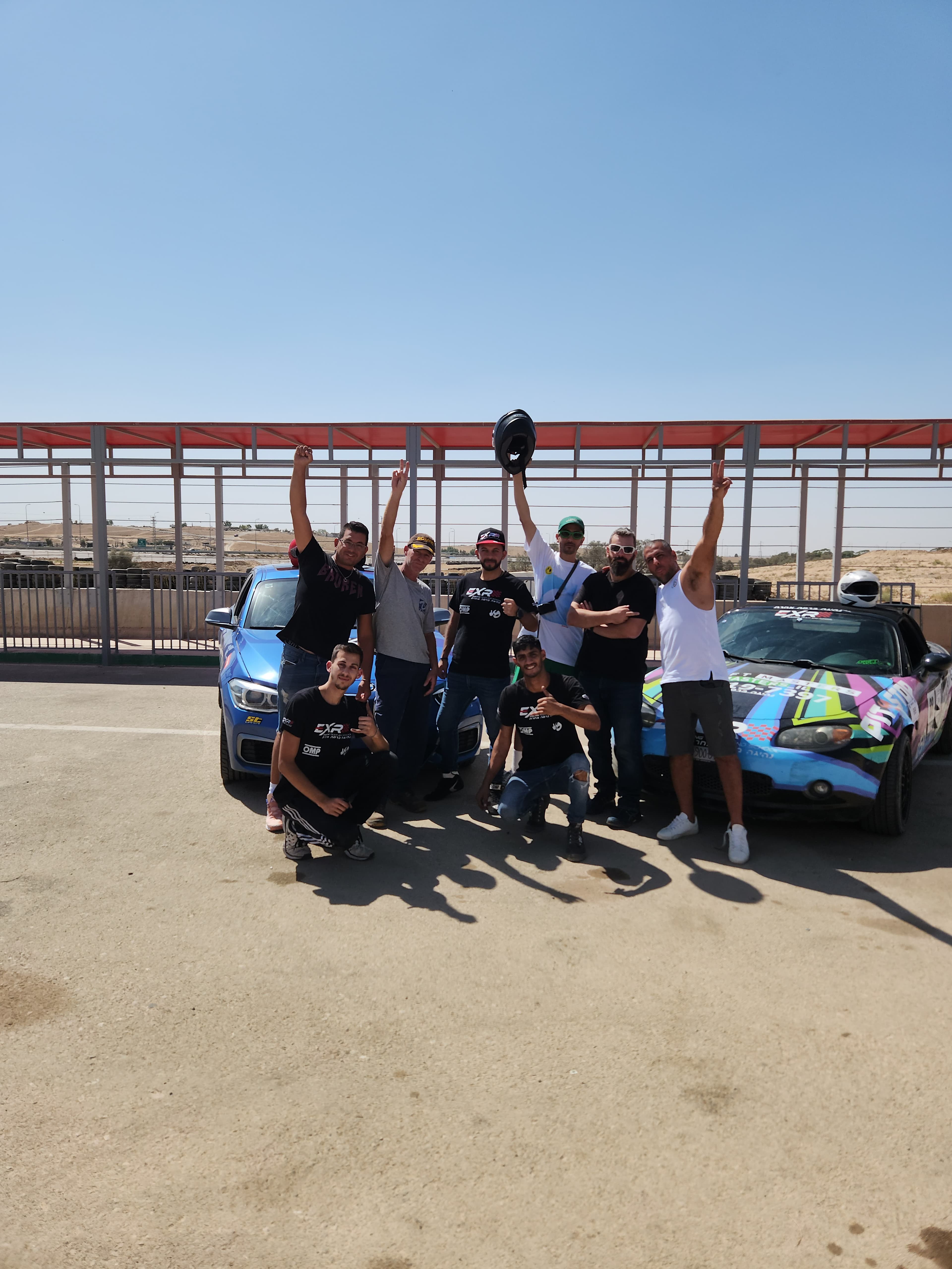 תמונה קבוצתית של לקוחות וצוות EXR עם רכבי הצי במסלול